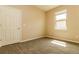 Bright bedroom with neutral walls and carpet, featuring a door and window at 406 Tortosa Ct, Davenport, FL 33837