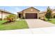 Exterior view of a charming house with a two car garage and well maintained landscaping at 406 Tortosa Ct, Davenport, FL 33837