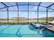 Enclosed pool and spa with lake view; lounge chairs and screened enclosure at 2857 Bookmark Dr, Kissimmee, FL 34746