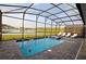 Enclosed pool and spa with lake view; lounge chairs and screened enclosure at 2857 Bookmark Dr, Kissimmee, FL 34746