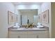 Bathroom with double vanity, large mirror, and coastal-themed artwork at 2857 Bookmark Dr, Kissimmee, FL 34746