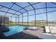 Enclosed pool and spa with lake view; lounge chairs and screened enclosure at 2857 Bookmark Dr, Kissimmee, FL 34746