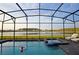 Enclosed pool and spa with lake view; lounge chairs and screened enclosure at 2857 Bookmark Dr, Kissimmee, FL 34746