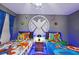 Twin beds in a superhero themed bedroom with wall art and blue lighting at 2857 Bookmark Dr, Kissimmee, FL 34746