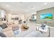 Open living room with sectional sofa and large TV, leading to the kitchen at 1959 Tropical Palms Cir, Kissimmee, FL 34747