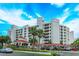 White building with red accents, palm trees, and parking lot at 1 John Anderson Dr # 604, Ormond Beach, FL 32176