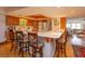 Kitchen with wood cabinets, breakfast bar, and views to living room at 1 John Anderson Dr # 604, Ormond Beach, FL 32176