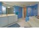 Spa-like bathroom with soaking tub, shower, and blue walls at 1 John Anderson Dr # 604, Ormond Beach, FL 32176