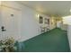 Building hallway with green carpet, white walls, and small seating area at 1 John Anderson Dr # 604, Ormond Beach, FL 32176