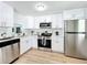 Modern kitchen with white cabinets and stainless steel appliances at 241 Menlo Park Ave, Davenport, FL 33897