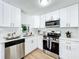 Modern kitchen with white cabinets and stainless steel appliances at 241 Menlo Park Ave, Davenport, FL 33897