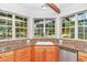 Kitchen corner sink with granite countertop and view of the backyard through large windows at 8901 Nw 136Th Avenue Rd, Ocala, FL 34482