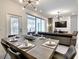 Modern dining room with a large table and view into the living room and kitchen at 7472 Oakmoss Loop, Davenport, FL 33837