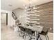 Modern dining room with a wooden accent wall and staircase at 7472 Oakmoss Loop, Davenport, FL 33837