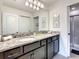 Double vanity bathroom with granite countertop and shower at 7472 Oakmoss Loop, Davenport, FL 33837