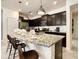 Modern kitchen with dark cabinets, granite countertops, and an island at 7472 Oakmoss Loop, Davenport, FL 33837