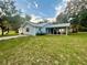 Light blue house with carport, solar panels, and large grassy yard at 13659 Sw 115Th Pl, Dunnellon, FL 34432