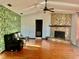 Living room with stone fireplace and leafy wallpaper accent wall at 13659 Sw 115Th Pl, Dunnellon, FL 34432