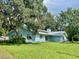 Light blue house nestled among large oak trees with Spanish moss at 13659 Sw 115Th Pl, Dunnellon, FL 34432