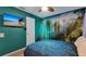 Bedroom with a rainforest mural, blue bedding, and TV at 7724 Comrow St, Kissimmee, FL 34747