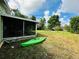 Green kayak rests in the spacious backyard with screened patio at 6004 Hilltop E Ln, Lakeland, FL 33809