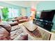 Living room with brown couches, coffee table, and view into kitchen at 6004 Hilltop E Ln, Lakeland, FL 33809