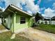 Green house exterior with a driveway and small yard at 6004 Hilltop E Ln, Lakeland, FL 33809