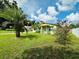 Light green house exterior with a yard and palm tree at 6004 Hilltop E Ln, Lakeland, FL 33809