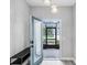 Open and airy entryway with teal door and sleek console table at 1126 Whitewater Bay Dr, Groveland, FL 34736