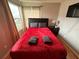Cozy bedroom with red bedding and a large window at 2729 N Poinciana Blvd # 117, Kissimmee, FL 34746