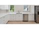 Modern kitchen with white cabinets, quartz countertops, and stainless steel dishwasher at 450 Avenue B Ne, Winter Haven, FL 33881