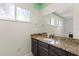 Bathroom with granite countertop, dark brown vanity, and updated fixtures at 6318 Cedar Ln, Lakeland, FL 33813