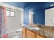 Bathroom with blue walls, granite countertop, and a tub shower combo at 6318 Cedar Ln, Lakeland, FL 33813