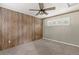 Bedroom with wood-paneled accent wall, neutral carpeting, and ceiling fan at 6318 Cedar Ln, Lakeland, FL 33813