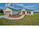 Single-story home with green metal roof and attached garage at 7031 Red Grange Boulevard Ave, Indian Lake Estates, FL 33855