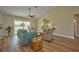 Relaxing living room with teal sofa, wicker chairs, and wood-look flooring, plus sliding glass doors at 7031 Red Grange Boulevard Ave, Indian Lake Estates, FL 33855