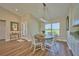 Light-filled dining area showcasing a round wooden table, white chairs, and wood-look flooring at 7031 Red Grange Boulevard Ave, Indian Lake Estates, FL 33855