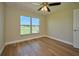Bedroom with window, ceiling fan and wood-look floors at 7031 Red Grange Boulevard Ave, Indian Lake Estates, FL 33855