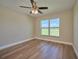 Bright bedroom with a large window, ceiling fan and wood-look floors at 7031 Red Grange Boulevard Ave, Indian Lake Estates, FL 33855