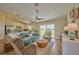 Open living space with teal sofa, kitchen view, and sliding doors at 7031 Red Grange Boulevard Ave, Indian Lake Estates, FL 33855