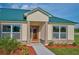Front entrance with a decorative door and landscaping at 7031 Red Grange Boulevard Ave, Indian Lake Estates, FL 33855