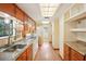 Long kitchen with wood cabinets, granite counters and white appliances at 3603 Cr 626N, Bushnell, FL 33513