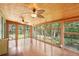 Bright sunroom with wood floors and ceiling fans, offering wooded views at 3603 Cr 626N, Bushnell, FL 33513