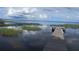 Serene waterfront property with a wooden dock extending over calm lake waters at 10742 W Beach Pkwy, Lake Wales, FL 33898
