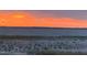 Stunning sunset over a tranquil lake with calm water and marshy shoreline at 10742 W Beach Pkwy, Lake Wales, FL 33898