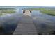 Wooden dock extending over calm lake water with lush vegetation at 10742 W Beach Pkwy, Lake Wales, FL 33898
