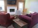 Living room with fireplace, rocking chair, and maroon couches at 10742 W Beach Pkwy, Lake Wales, FL 33898