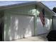 Two car garage with white doors and an American flag at 10742 W Beach Pkwy, Lake Wales, FL 33898