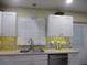 Updated kitchen with white cabinets, a window, and modern sink at 10742 W Beach Pkwy, Lake Wales, FL 33898