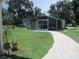 Screened enclosure with a brick path and lush green lawn at 10742 W Beach Pkwy, Lake Wales, FL 33898